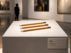 Lo stato dell’arte – Il Valore dell’arte “Tre”. Tre semplici matite entrano nello spazio del museo. La materia è rimasta la stessa; intorno a loro comincia a costruirsi il riconoscimento dell’opera. (Immagine creata con IA – Orchestratore Eko.)